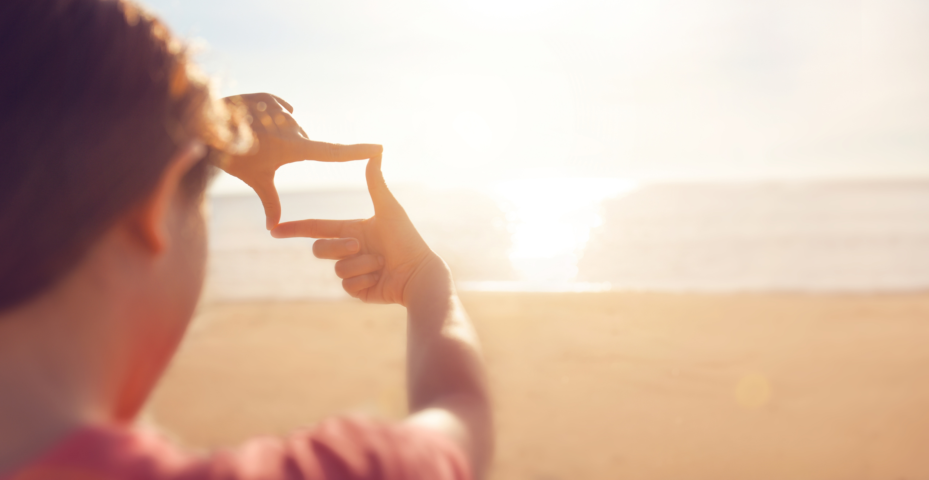 Future planning, hands making frame gesture with sunrise on sea summer